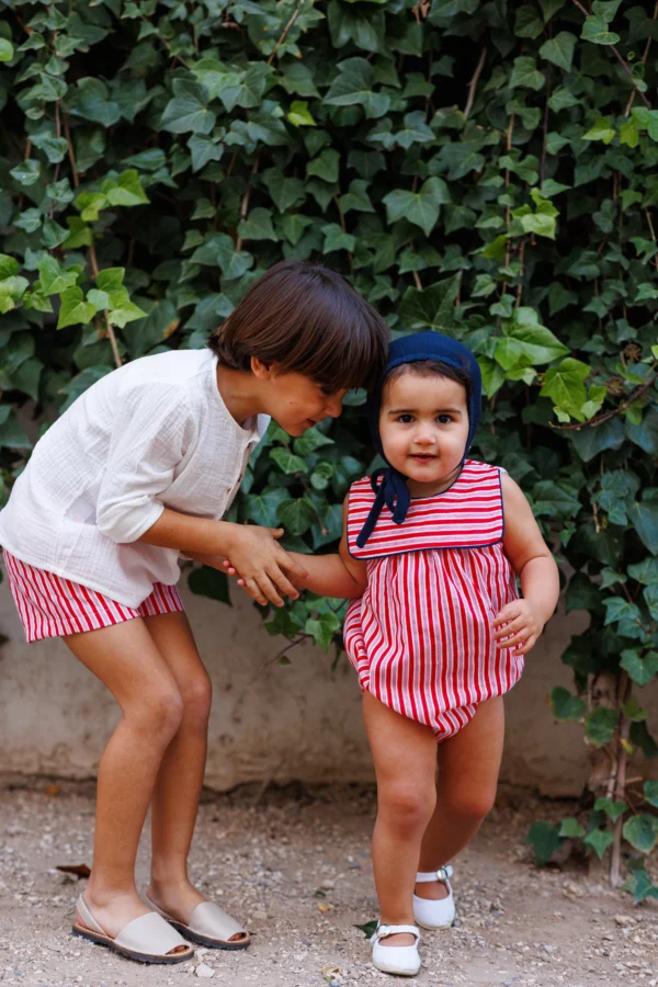 Hermanos vestidos igual rayas rojas